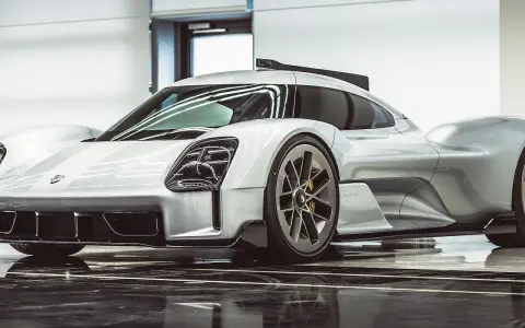 Silberner Porsche Hypercar mit aggressiven Linien und auffälligen Scheinwerfern, bereit für die Rennstrecke.