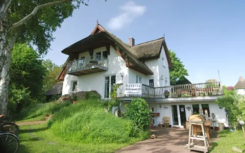 Galerie "Schnepel III" mit Kunsthandwerk und Veranstaltungen. Ein charmantes Haus mit Reetdach und Balkon.