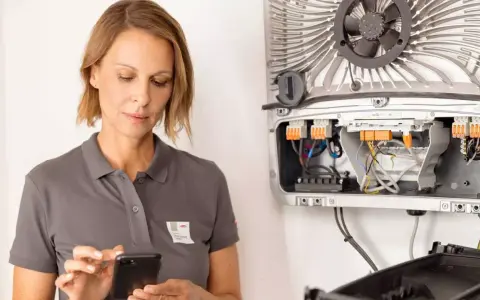 Tekniker använder mobil för att övervaka byd hvs-systemet.