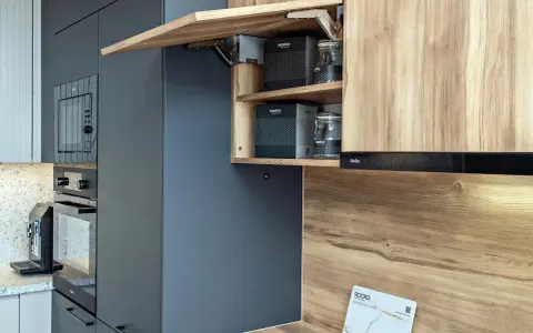 Nowoczesna aranżacja małej kuchni 4m2. Drewniane fronty szafek i ciemnoszare panele tworzą stylową całość.