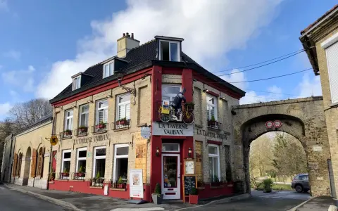 Façade de la Taverne Vauban à Bergues, avec une enseigne et une décoration de cycliste.