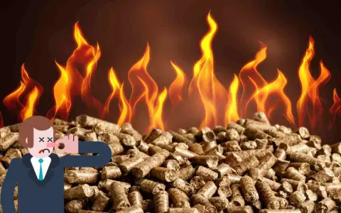Uomo con naso tappato su mucchio di pellet, fiamme sullo sfondo. La stufa pellet puzza da spenta.