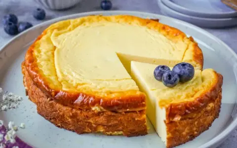 Ein köstlicher Quarkkuchen ohne Boden, mit Blaubeeren garniert, wartet darauf, genossen zu werden.
