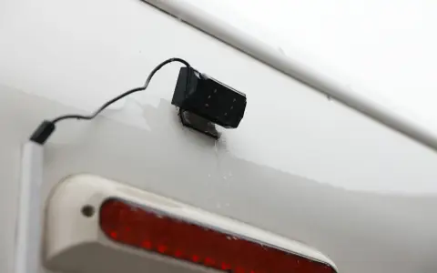 En liten svart backkamera monterad på en vit yta, redo att installera för bättre sikt bakåt.