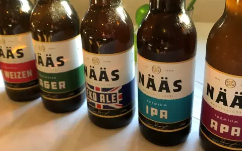 Flera flaskor öl från Nääs bryggeri står uppradade. En flaska med etiketten "Eko Ale" syns tydligt.