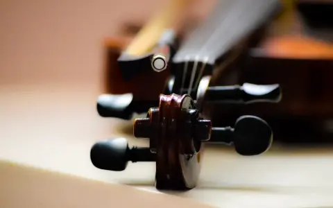 Główka skrzypiec, instrumentu podobnego do oratorium, z widocznymi kluczami i fragmentem smyczka.