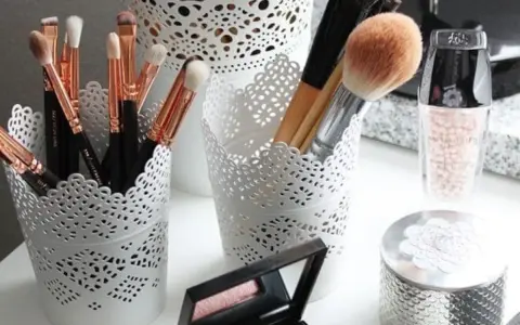 Des pinceaux de maquillage et des produits de beauté dans des pots ajourés. Une belle organisation pour le recyclage du maquillage.