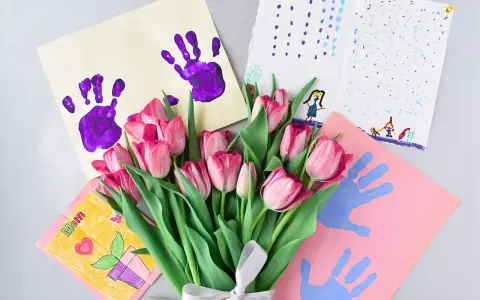 Bukiet różowych tulipanów i laurki z odciskami dłoni, idealne co na Dzień Kobiet w przedszkolu.