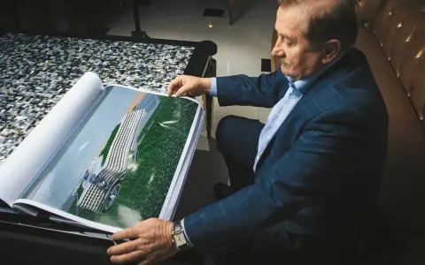 Henryk Gołębiewski, właściciel hoteli, ogląda projekt nowoczesnego hotelu zlokalizowanego nad wodą.