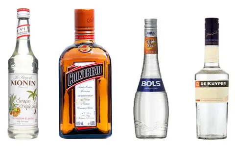 Butelki likierów: Monin Curacao Triple Sec, Cointreau, Bols Triple Sec i De Kuyper. Triple sec to pomarańczowy likier.