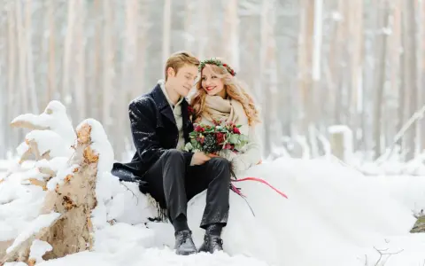 Para młoda w zimowej scenerii. Romantyczny ślub w styczniu w otoczeniu śniegu i drzew.