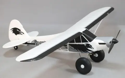 Modellflugzeug Piper PA-18 mit Adler-Design, bereit zum Abheben.