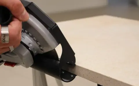 Hand mit Ring hält Winkelschleifer zum präzisen Fliesenschneiden.
