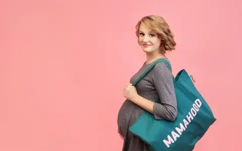 Przyszła mama z torbą "Mamahood" gotowa na wyprawkę do szpitala.