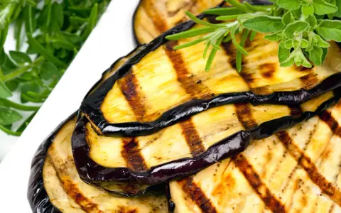 Gegrillte Auberginenscheiben mit Kräutern garniert. Perfekt für ein leckeres Aubergine einlegen.