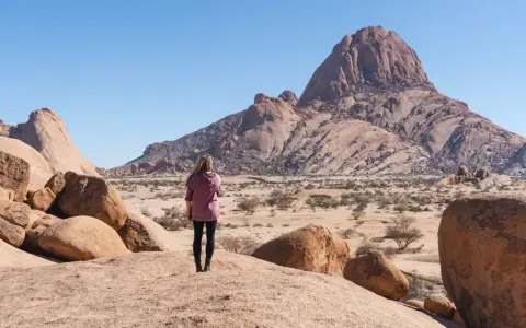 Kobieta podziwia pustynny krajobraz Namibii. Sprawdź ceny wycieczek!
