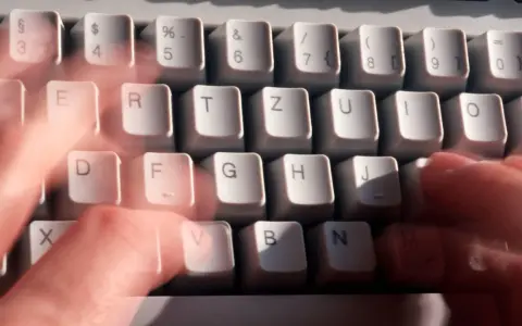 Hände tippen schnell auf einer Tastatur. Vielleicht wird gerade ein Befehl wie "diskpart delete partition" eingegeben.