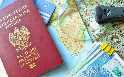 Polski paszport, pieniądze, mapa świata i akcesoria podróżne.