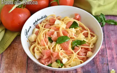 Spaghetti freschi con pomodorini, mozzarella e basilico, un piatto estivo perfetto: pasta alla checca.