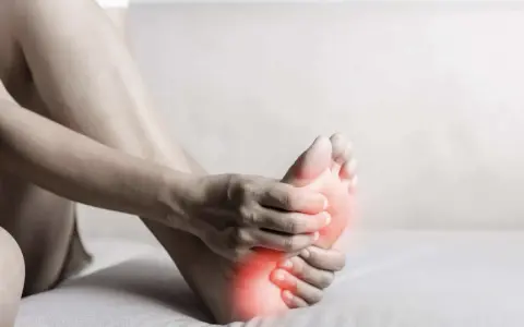 A person holds their foot, with red highlights indicating discomfort. This image evokes the feeling of needing natural foot detox.