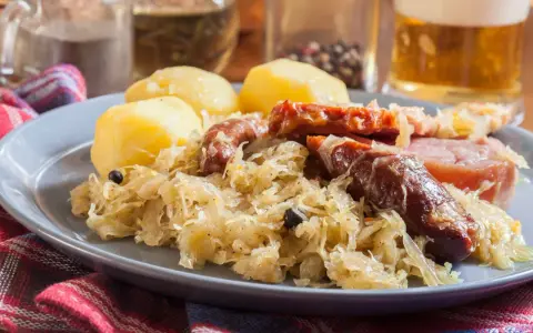 Assiette de choucroute garnie avec pommes de terre, saucisses et lard. Un plat typique de restaurant.