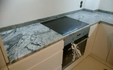 Elegancki blat granitowy 2 czy 3 cm z wbudowaną płytą indukcyjną i piekarnikiem.
