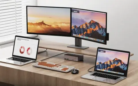 Dwa monitory i dwa laptopy na biurku. Dowiedz się, jak podłączyć dwa monitory do laptopa z jednym HDMI, używając stacji dokującej.
