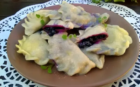 Pyszne pierogi z jagodami, delikatne i pełne owocowego smaku. Idealne na deser lub śniadanie.