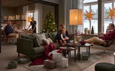 En familj njuter av en mysig julkväll med en sprakande brasa med lugn julmusik. Presenter och julgran bidrar till stämningen.