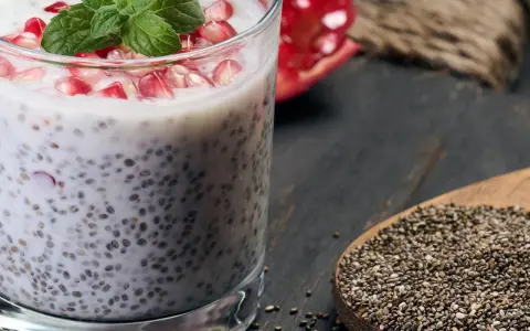 Chia-Samen-Pudding mit Granatapfel und Minze. Bei übermäßigem Verzehr können Chia-Samen Nebenwirkungen haben, auch für die Leber.