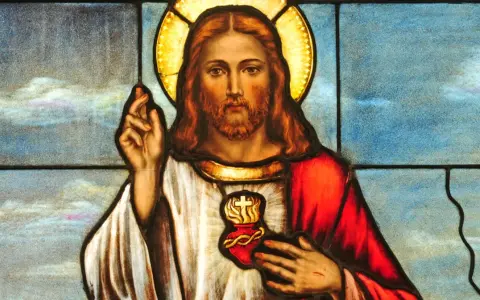 Witraż przedstawiający Jezusa z gorejącym Sercem, symbol głębokiej religii i miłości.