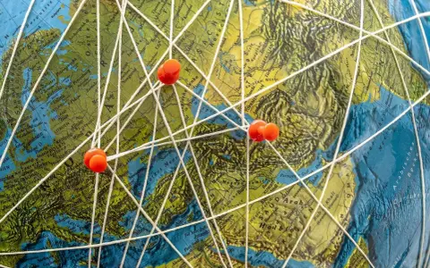 Marzenia o podróżach do Mozambiku? Mapa świata z zaznaczonymi trasami i pineskami symbolizuje plany na wakacje.
