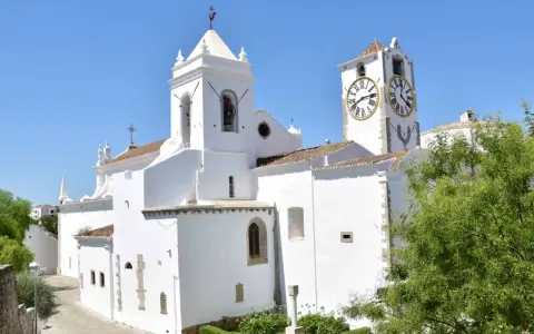 Weiße Kirche mit Glockenturm und Uhr im Herzen der tavira altstadt.