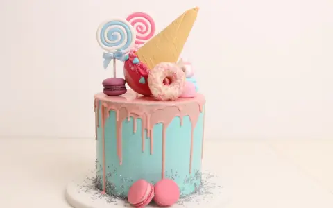 Bunter Drip Cake mit rosa Glasur, Lollis, Macarons und einem Eiswaffel-Horn.
