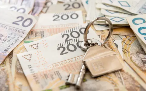 Klucze do domu na stosie polskich banknotów. Może to symbolizuje spłatę kredytu hipotecznego lub inwestycję, a może nawet windykację Santander.