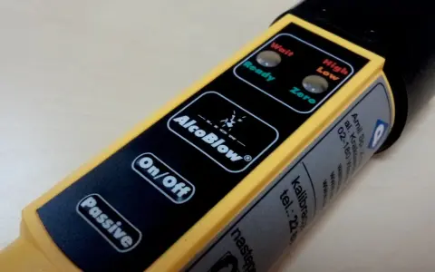 Alkomat AlcoBlow - gdzie można sprawdzić trzeźwość. Wskaźniki "Wait", "Ready", "High", "Low", "Zero" i przyciski "On/Off", "Passive".