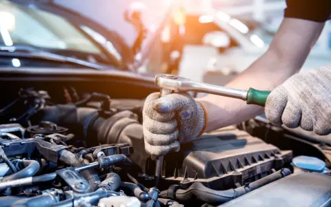 Mecánico revisa el motor de un coche. Aprende como saber si un motor esta quemado observando los componentes.