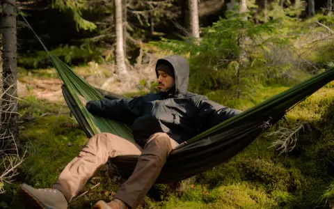 Mężczyzna w hamaku w lesie. To jest właśnie bushcraft – sztuka przetrwania i życia w zgodzie z naturą.