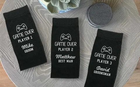 Tres calcetines negros personalizados con temática de videojuegos para boda, con nombres y roles.
