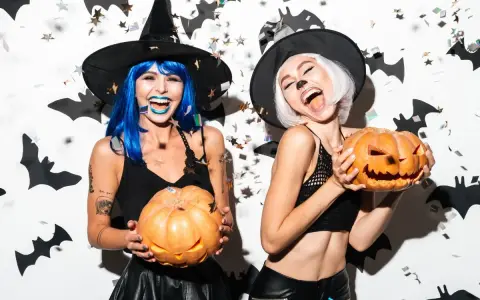 Dwie kobiety w strojach czarownic trzymają dynie. Świetne inspiracje na Halloween!
