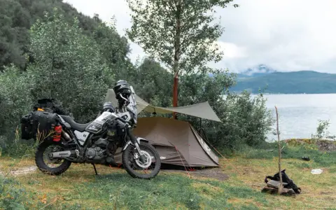 Motocyklem pod namiot nad jeziorem. Przygotowania do noclegu w dziczy.