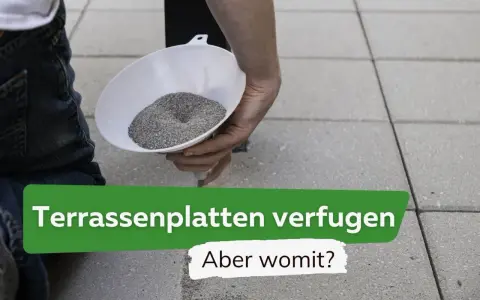 Eine Hand füllt mit einem Trichter feinen Sand in die Fugen von Terrassenplatten. So lassen sich Terrassenplatten verfugen.