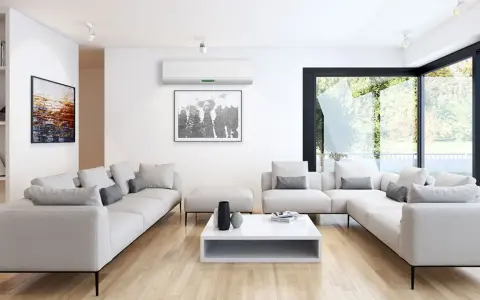 Salón moderno con sofás blancos, mesa de centro y aire acondicionado para la renovación de aire. Ventanal con vistas al jardín.