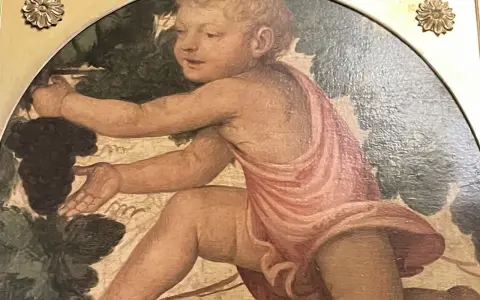 Enfant aux raisins, œuvre de Bernardino Luini, s'étire pour cueillir une grappe sombre.