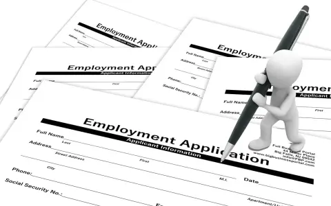 Biała figurka z długopisem wypełnia formularz "Employment Application" (ogłoszenie o pracę po ang.).