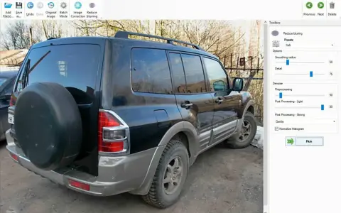 Software per correggere foto mosse. L'immagine mostra un SUV nero con una ruota di scorta sul retro, pronto per essere elaborato.