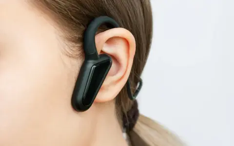 Czarna słuchawka bluetooth na uchu, idealna do rozmów w biegu.