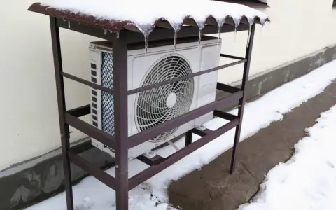 Unité extérieure de pompe à chaleur grand froid sous un abri enneigé. Avis sur sa performance en hiver.