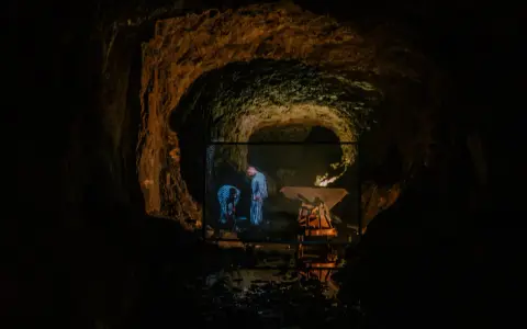 W jaskini wyświetlany jest film, na którym widać dwie postacie w pasiaste ubrania. Czy to osówka czy włodarz?