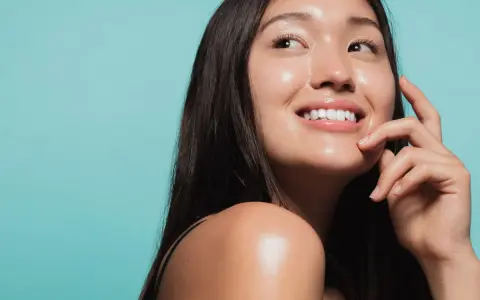 Donna sorridente con pelle luminosa e idratata, un esempio di come idratare la pelle senza creme.